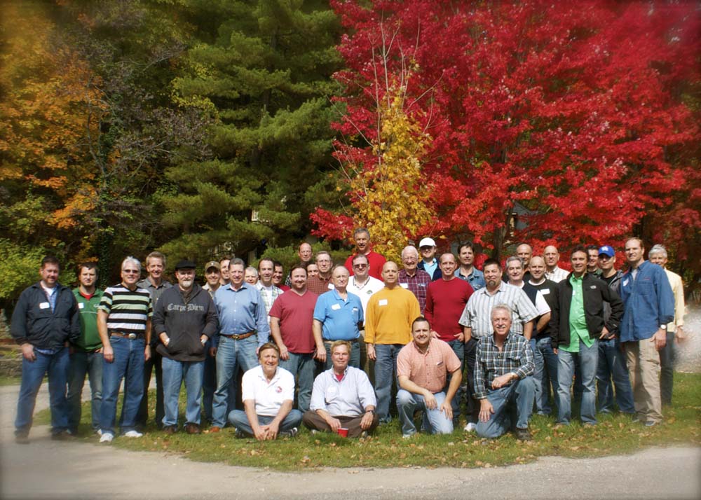 Group photo of Legacy Builders in front of fall colored trees