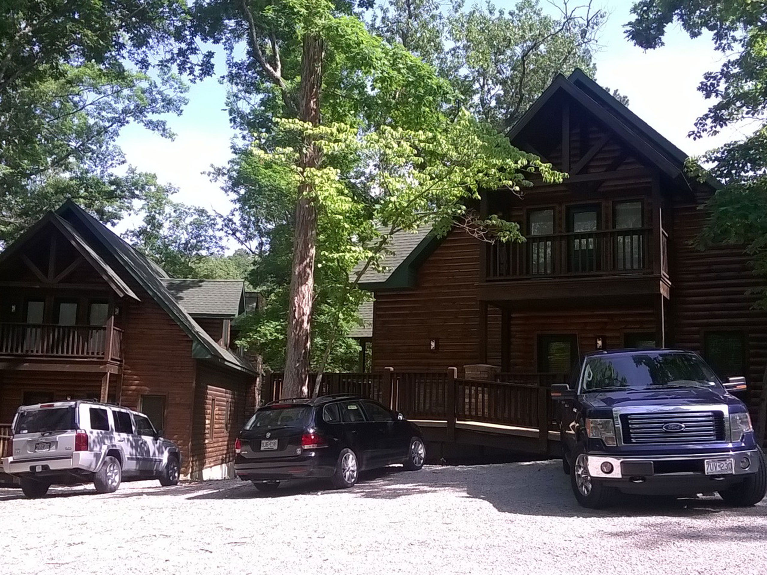 Two large cabins for Legacy Builders fishing Retreat with three vehicles parked in front