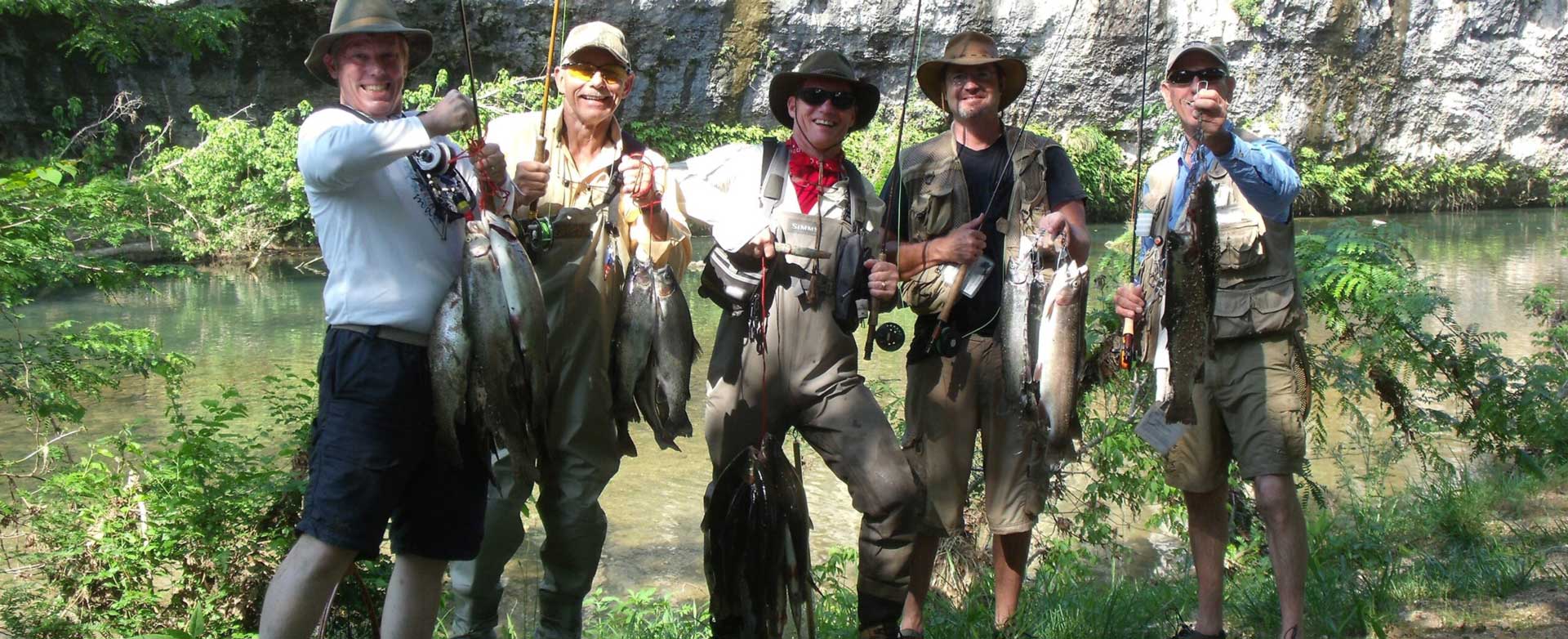 5 men holding their fish and poles during the fishing retreat with legacy builders
