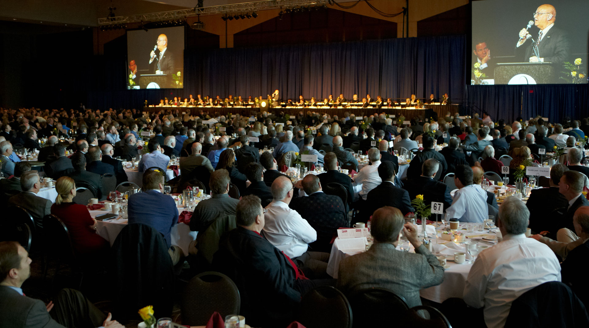 what-we-do-image Conference center filled with Legacy Builders breakfast listening to a speaker on the stage